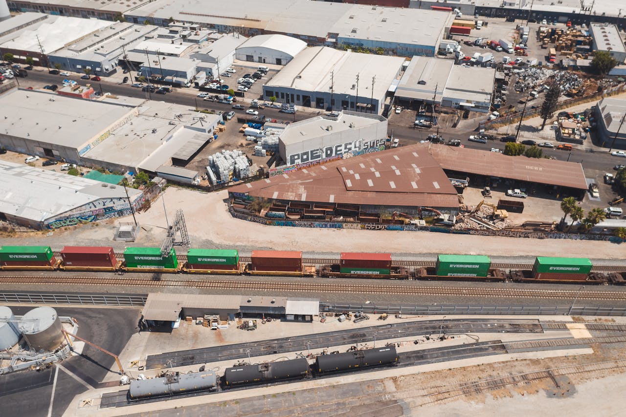 High-angle shot of an industrial area displaying train tracks and container rail cars.